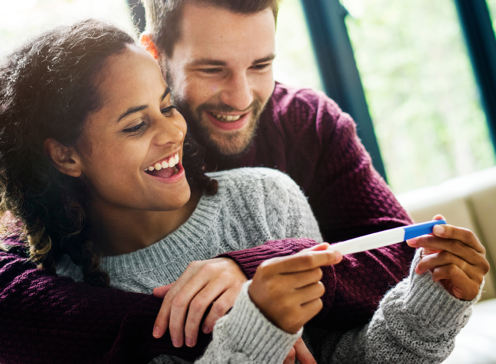 happy couple looking at pregnancy test