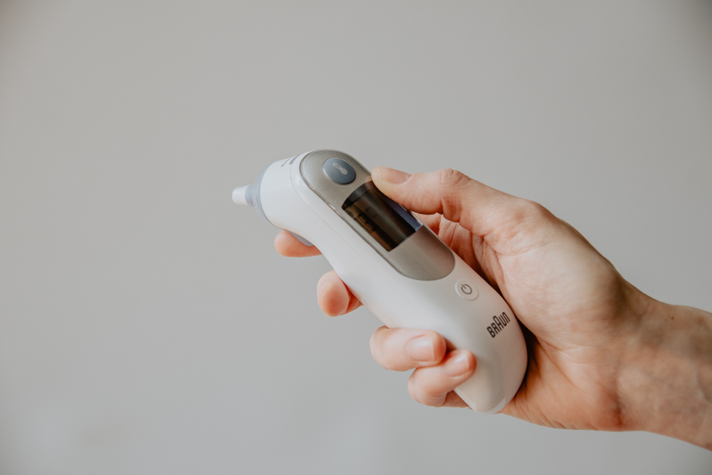 hand holding ear thermometer